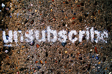 the word unsubscribe spray painted on pavement